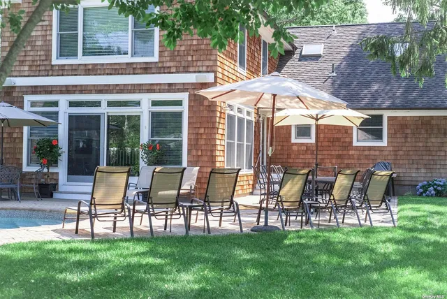 a patio with table and chairs and potted plants