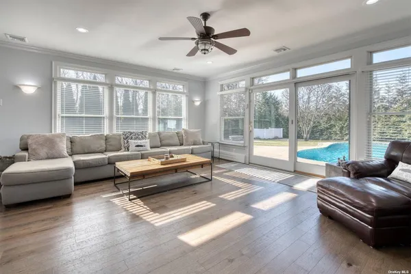 a living room with furniture and a large window with wooden floor