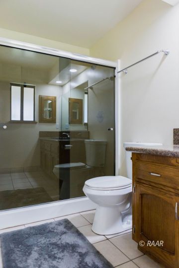327 Henry Street Ridgecrest, CA 93555 - Photo 18 of 30 a bathroom with a granite countertop sink a toilet and a mirror