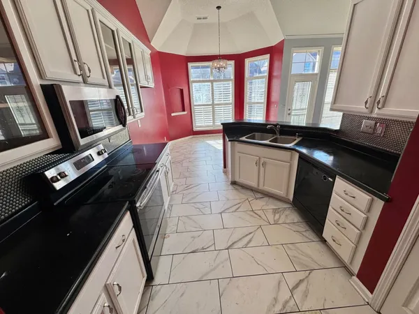 a kitchen with stainless steel appliances a sink stove and cabinets