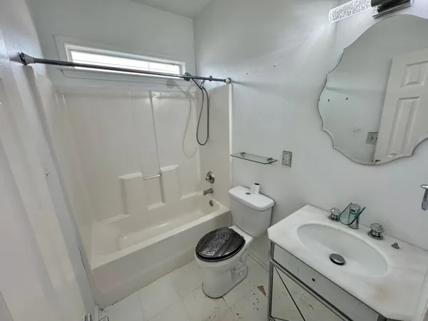 an empty room with a window and a ceiling fan