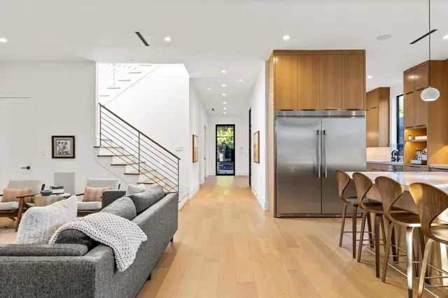 a living room with furniture and a refrigerator