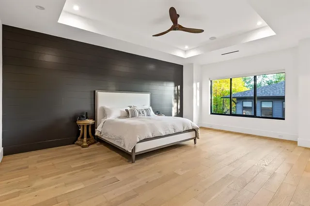 a bedroom with a bed and a large window