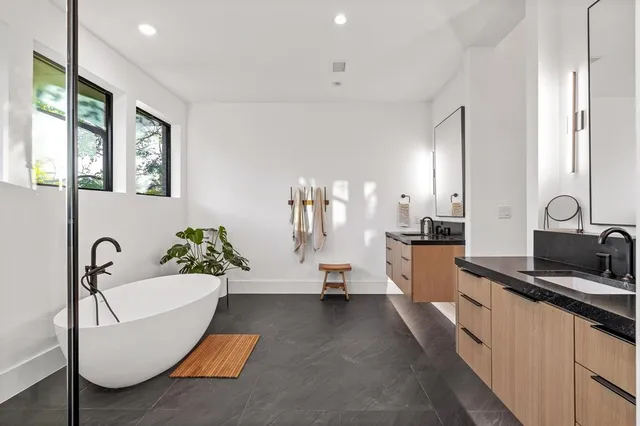 a spacious bathroom with a double vanity sink a mirror and a bathtub