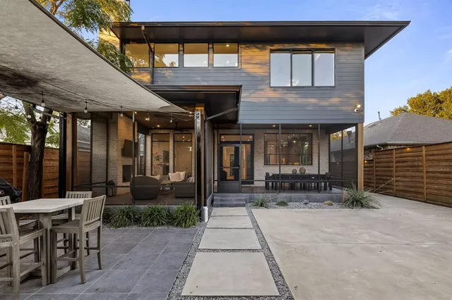 a view of a patio with table and chairs potted plants and floor to ceiling window