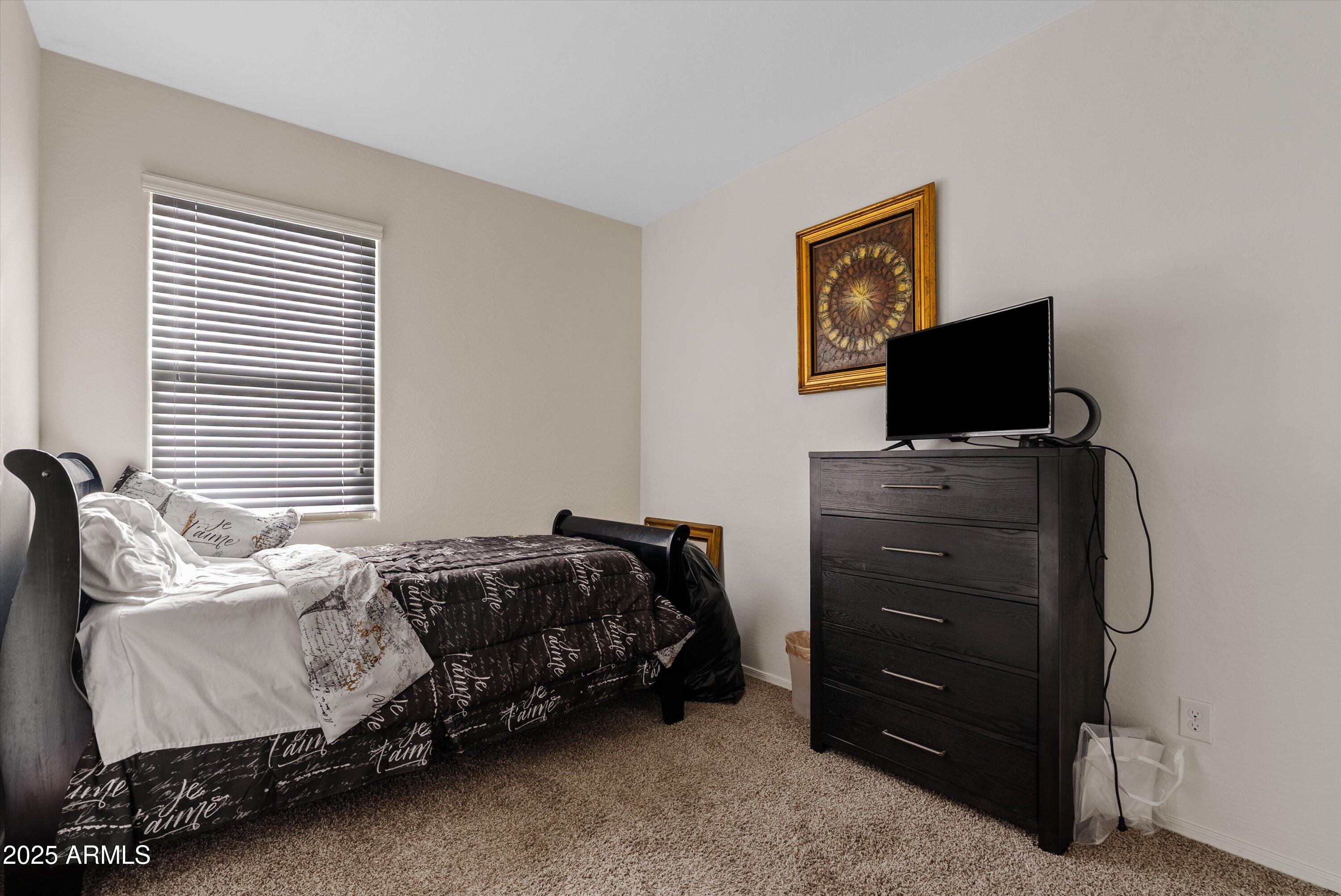 4708 South 26th Lane Phoenix, AZ 85041 - Photo 14 of 23 a bedroom with a bed and television