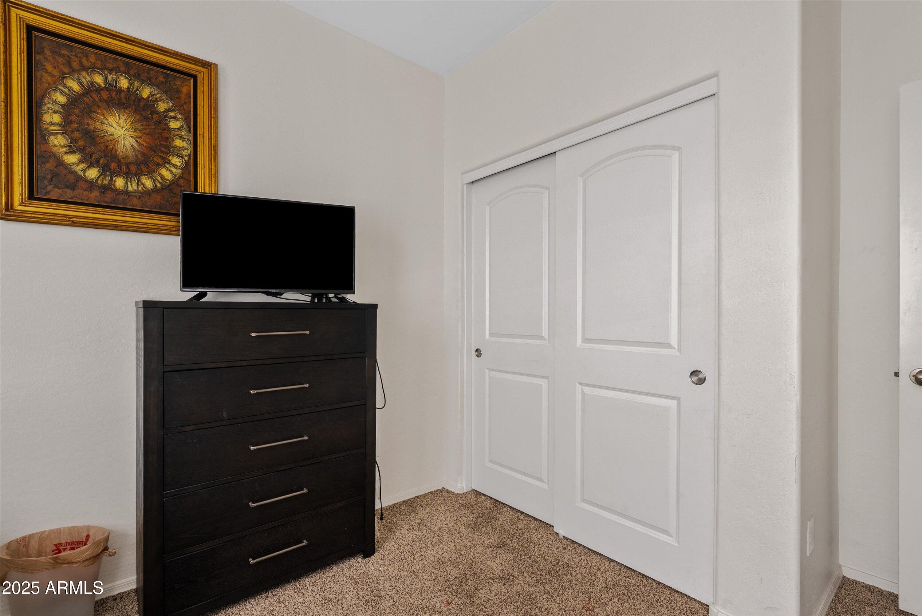 4708 South 26th Lane Phoenix, AZ 85041 - Photo 15 of 23 a television with a desk and a flat screen tv