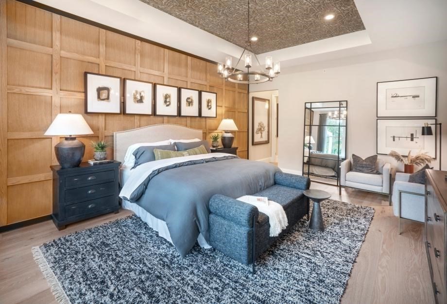 4 Broadleaf, Unit 15 Plymouth, MA 02360 - Photo 5 of 11 a bedroom with a bed a chandelier and a rug