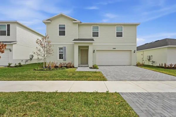 a front view of a house with a yard and garage
