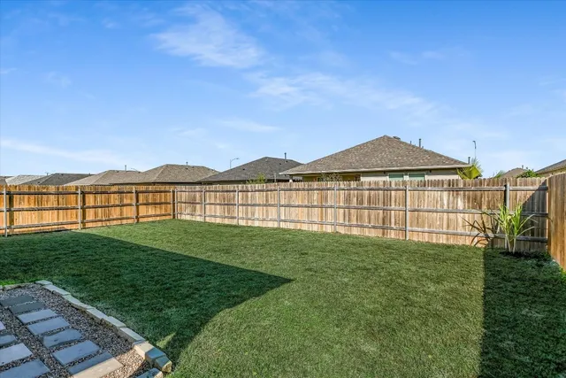 a view of a garden with a house in the background