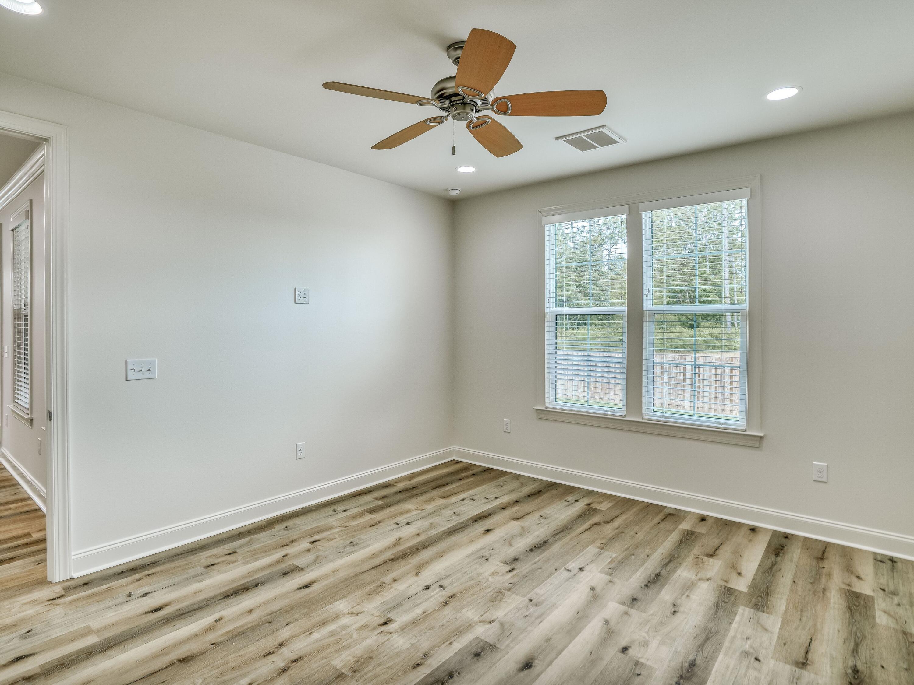 113 Conifer Court Watersound, FL 32461 - Photo 12 of 27 an empty room with wooden floor and windows