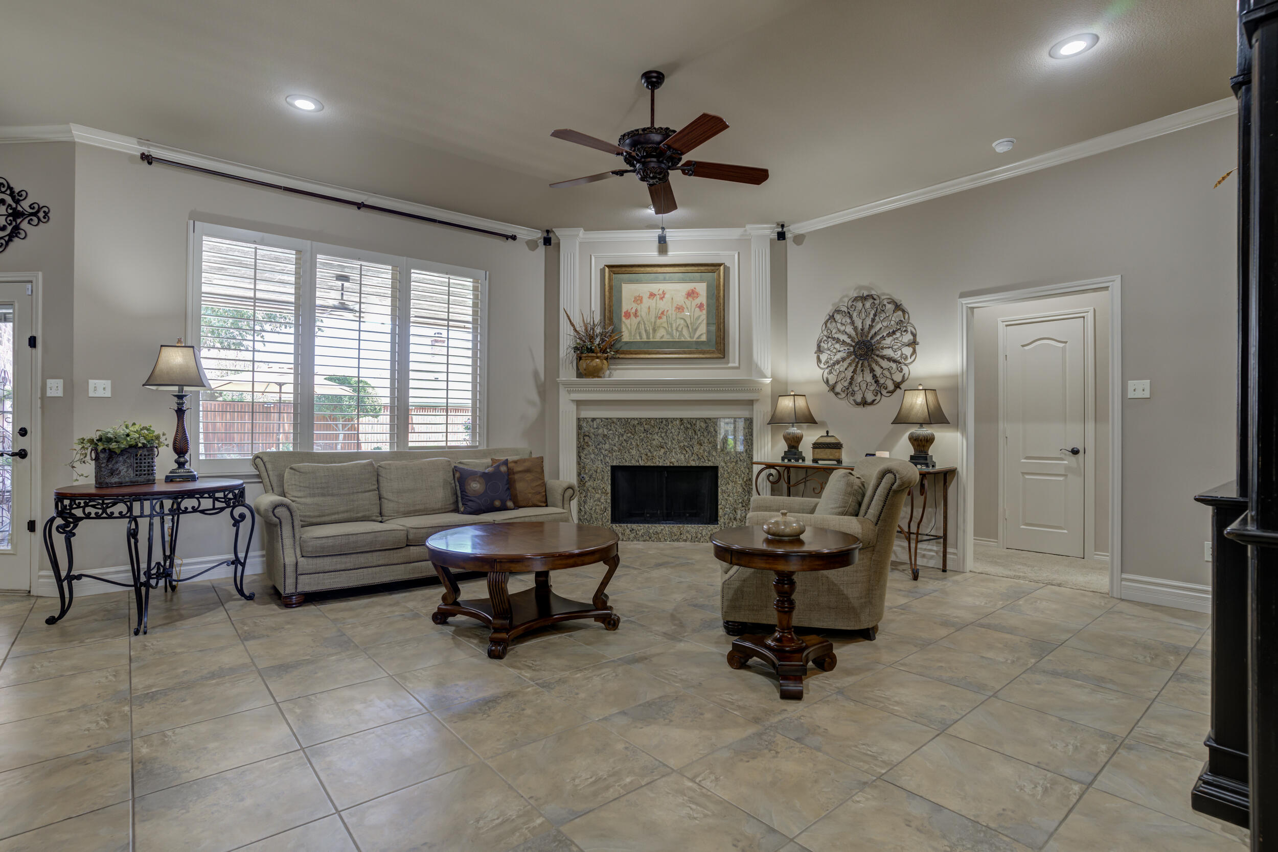 6008 89th Street Lubbock, TX 79424 - Photo 9 of 61 a living room with furniture a fireplace and a chandelier