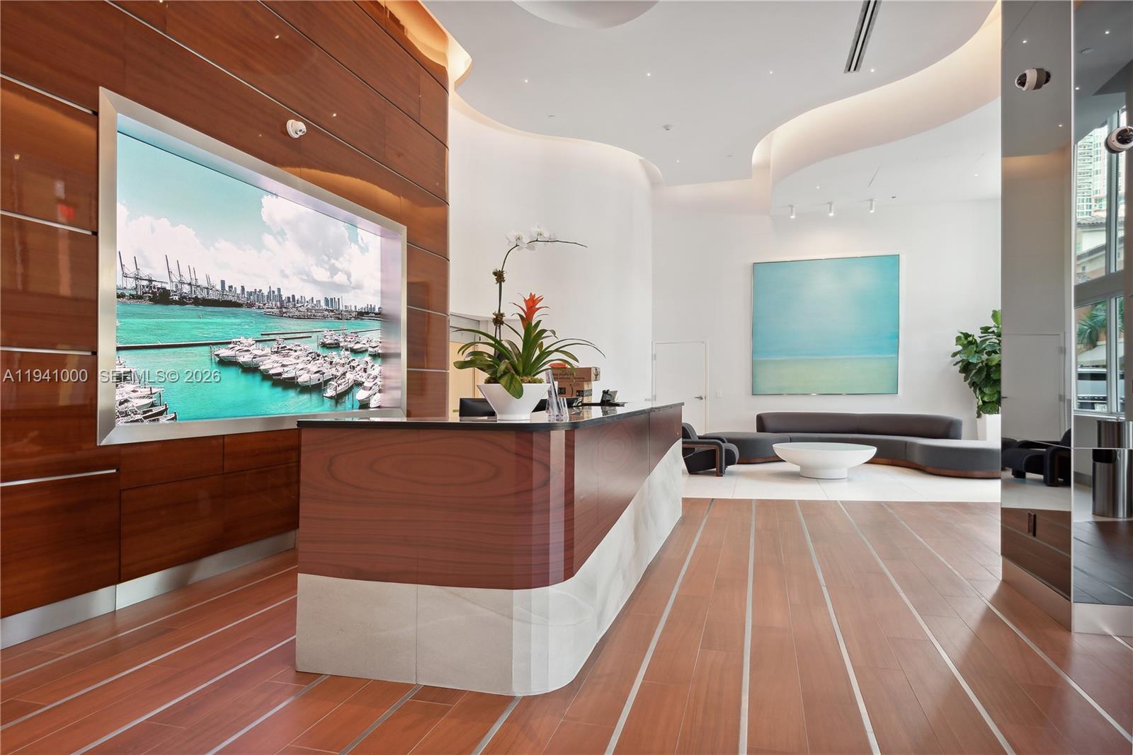 90 Alton Road, Unit 2803 Miami Beach, FL 33139 - Photo 18 of 21 a living room with large window and a table