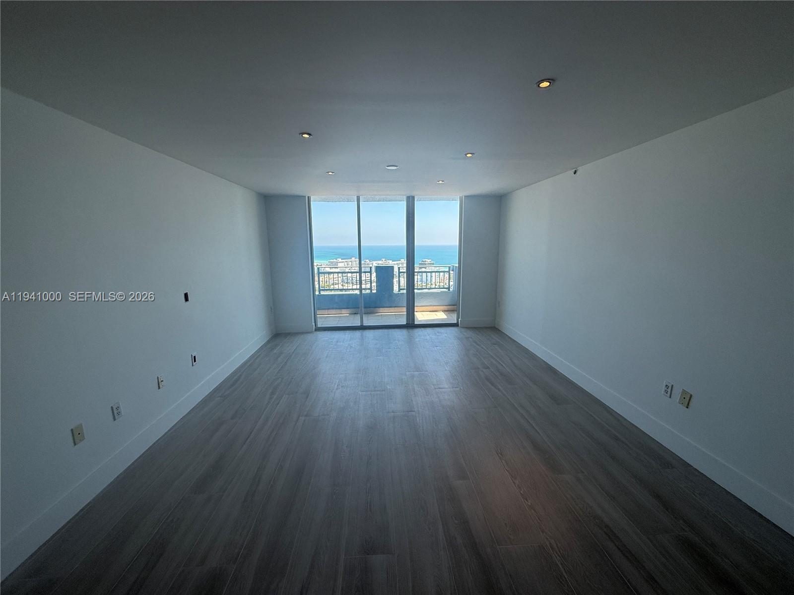 90 Alton Road, Unit 2803 Miami Beach, FL 33139 - Photo 2 of 21 a view of empty room with wooden floor and fan
