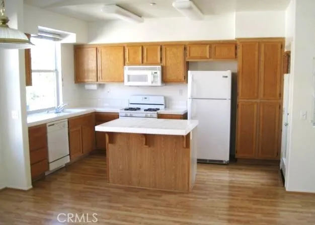 a kitchen with a sink appliances a window and a counter top space