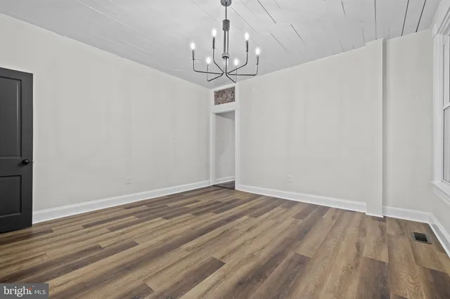a view of a room with wooden floor staircase and a kitchen space