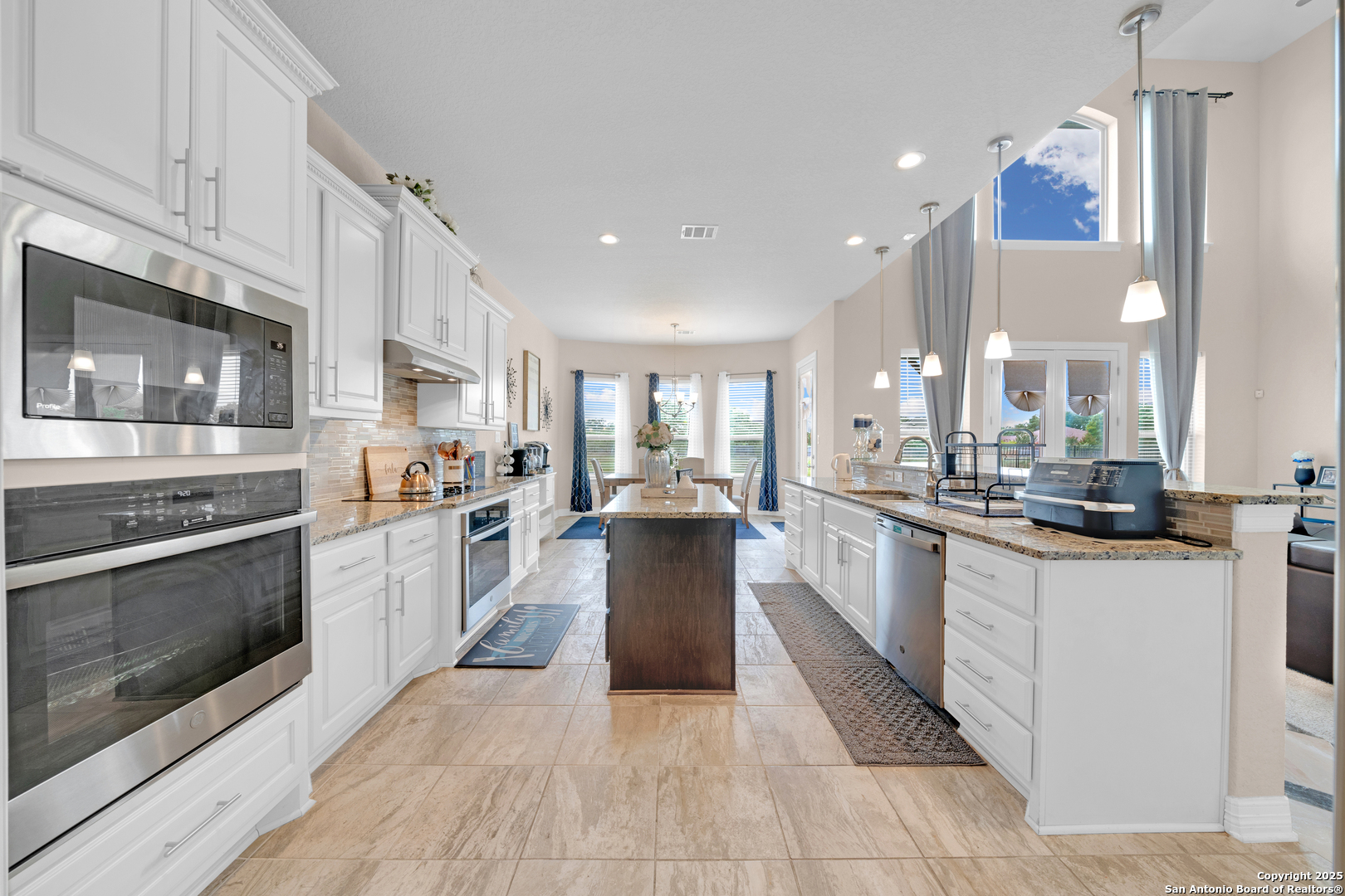 7151 Agarita Mist Fair Oaks Ranch, TX 78015 - Photo 11 of 49 a large kitchen with stainless steel appliances kitchen island granite countertop a large counter top and a stove