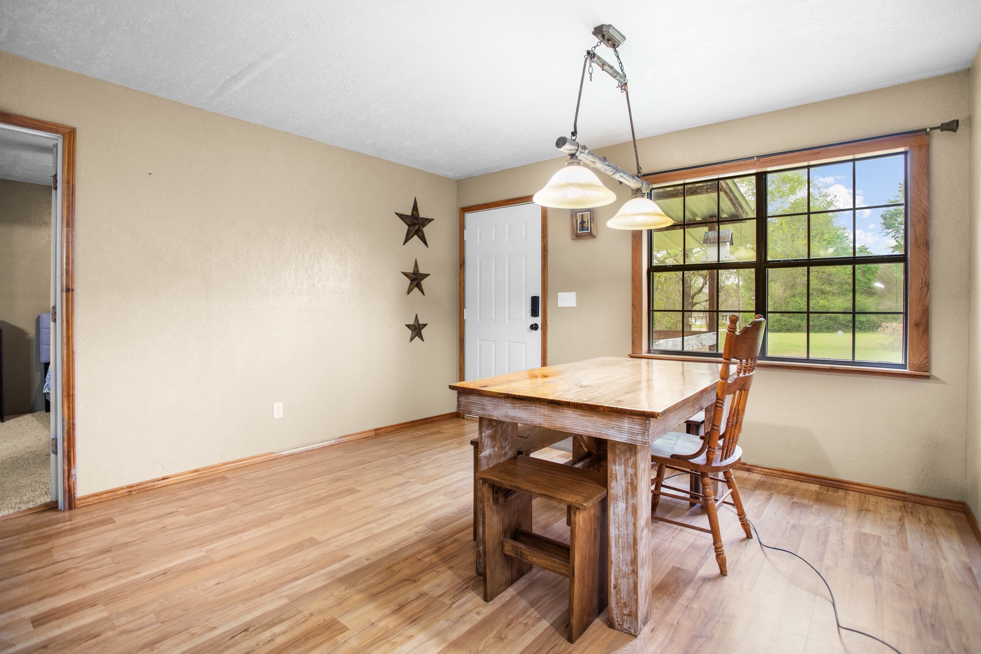 991 Herman Nerren Road Huntington, TX 75949 - Photo 9 of 23 a dining room with wooden floor a chandelier a wooden table and chairs