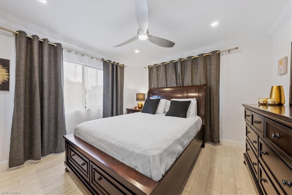 5841 Rattlesnake Hammock Road, Unit 2 Naples, FL 34113 - Photo 11 of 21 a bedroom with a bed and a chandelier