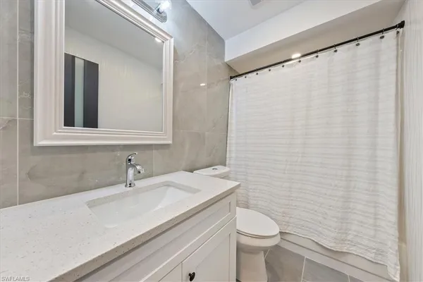a bathroom with a sink a toilet and shower curtain