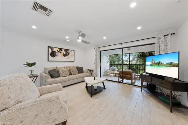 a living room with furniture flat screen tv and wooden floor