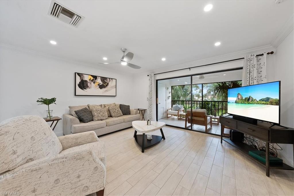 5841 Rattlesnake Hammock Road, Unit 2 Naples, FL 34113 - Photo 15 of 21 a living room with furniture flat screen tv and wooden floor