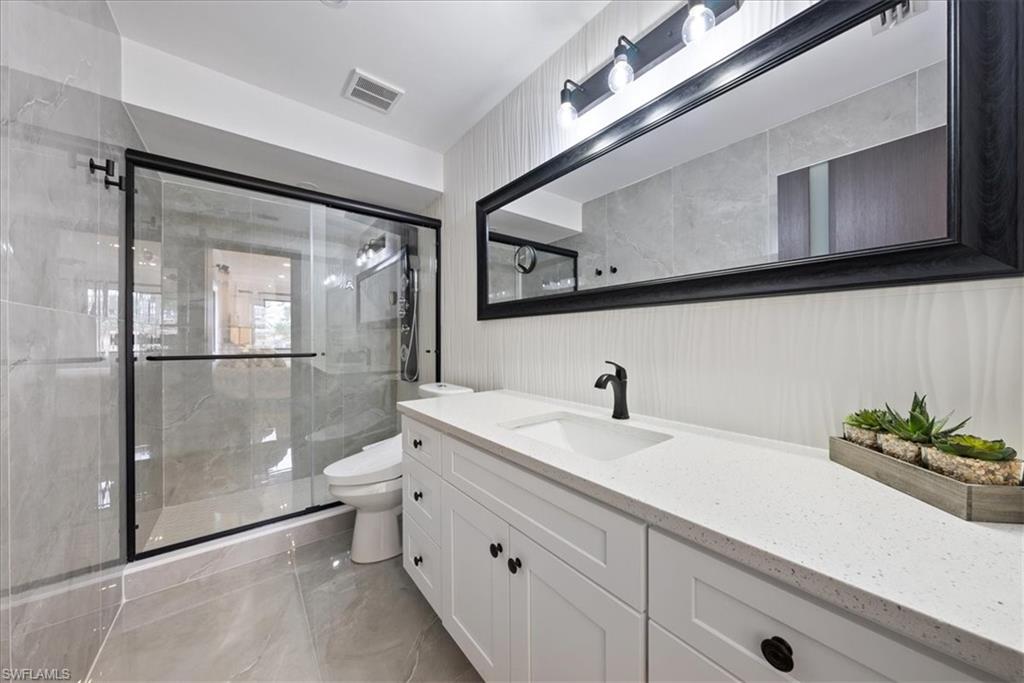 5841 Rattlesnake Hammock Road, Unit 2 Naples, FL 34113 - Photo 18 of 21 a bathroom with a sink a toilet and shower