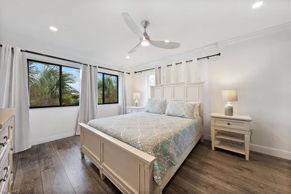 a bed sitting in a spacious bedroom next to a window