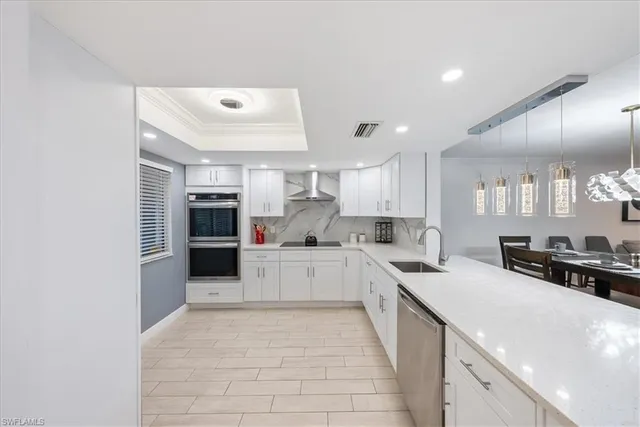 a large white kitchen with cabinets a sink and appliances