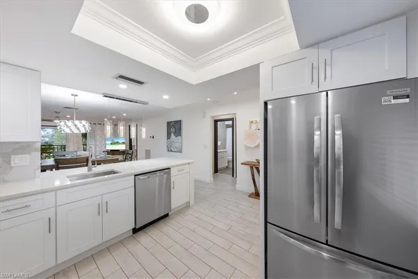 a kitchen with white cabinets and stainless steel appliances