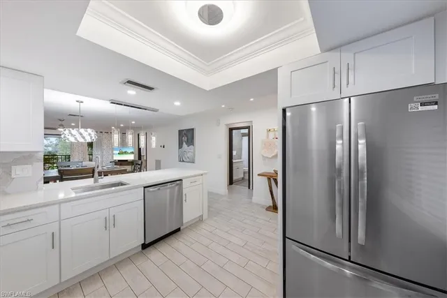 a kitchen with white cabinets and stainless steel appliances