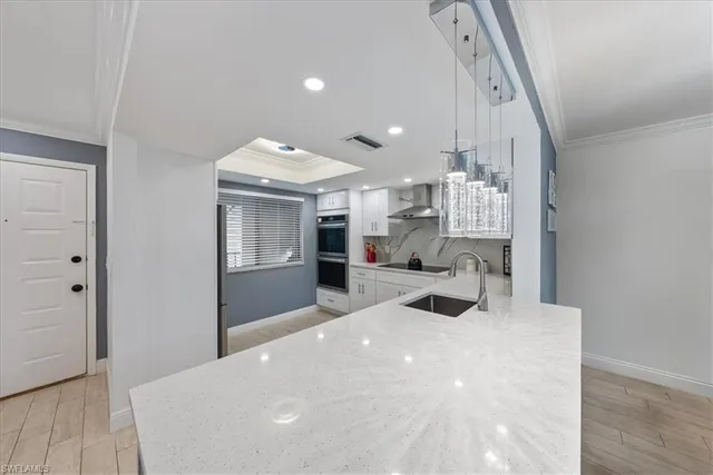 a large white room with kitchen view and living room