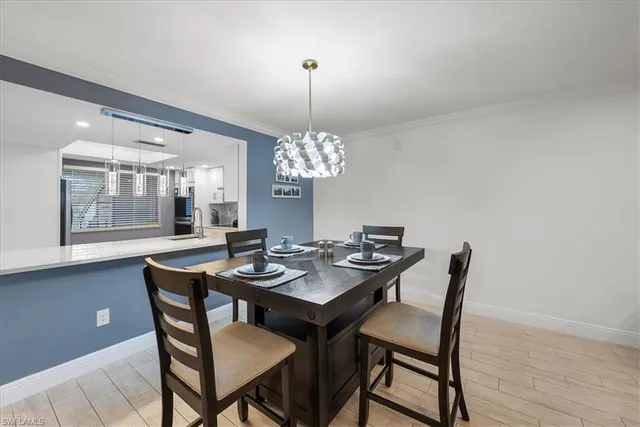 a dining room with furniture a chandelier and wooden floor