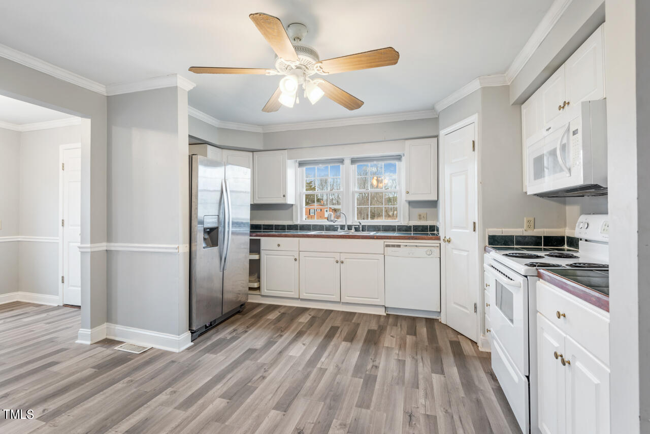 2034 Mt Harmony Church Road Rougemont, NC 27572 - Photo 3 of 40 a kitchen with white cabinets stainless steel appliances and a window