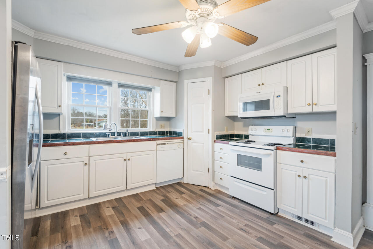 2034 Mt Harmony Church Road Rougemont, NC 27572 - Photo 10 of 40 a kitchen with stainless steel appliances granite countertop a stove a sink and white cabinets