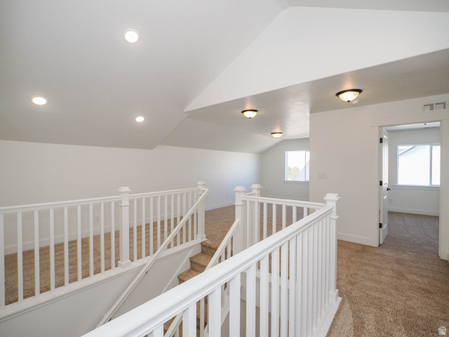 3938 North Wood Road Eagle Mountain, UT 84005 - Photo 31 of 55 Hall featuring lofted ceiling, light colored carpet, and an upstairs landing
