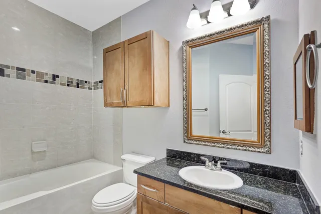 a bathroom with a granite countertop sink toilet and shower