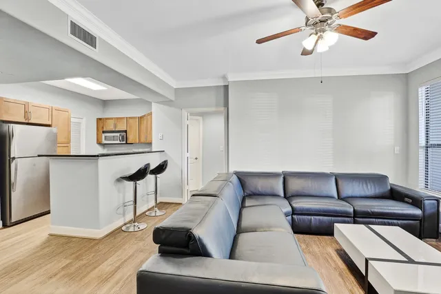 a living room with furniture and a wooden floor