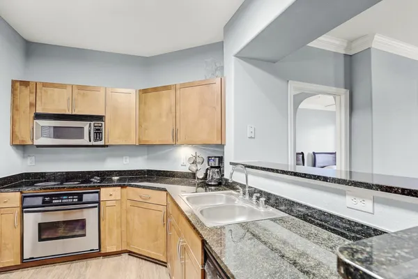 a kitchen with granite countertop a sink stove and cabinets