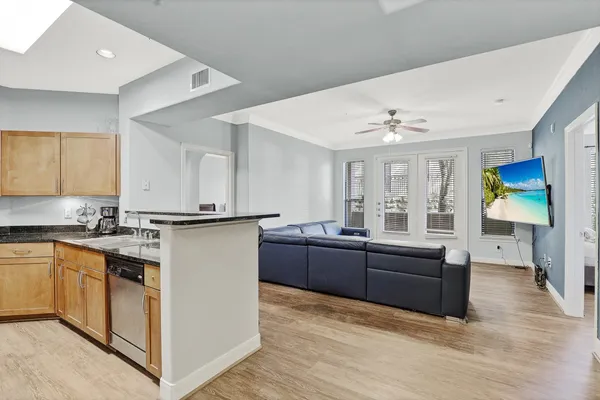 a large white kitchen with cabinets a sink and appliances