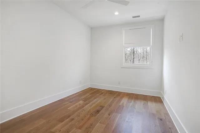 an empty room with wooden floor and a window