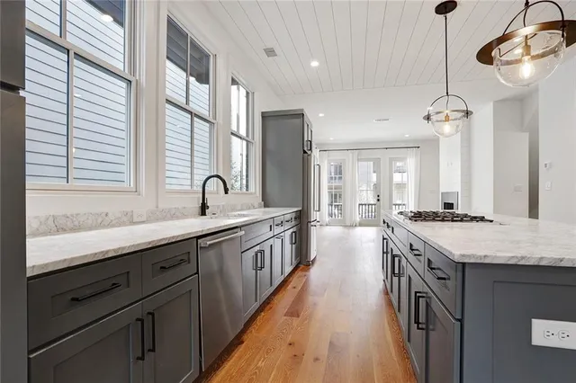 a large kitchen with kitchen island granite countertop lots of counter space and a sink