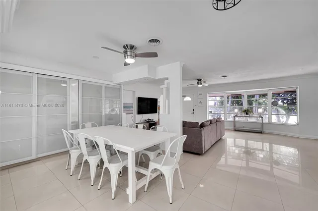 a large white kitchen with lots of counter top space and dining table