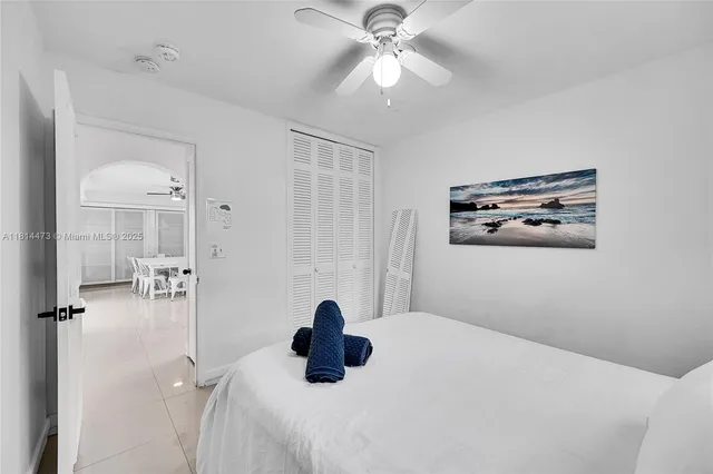 a bedroom with a bed and a ceiling fan