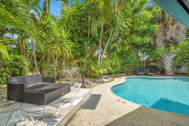 a backyard of a house with plants and large trees