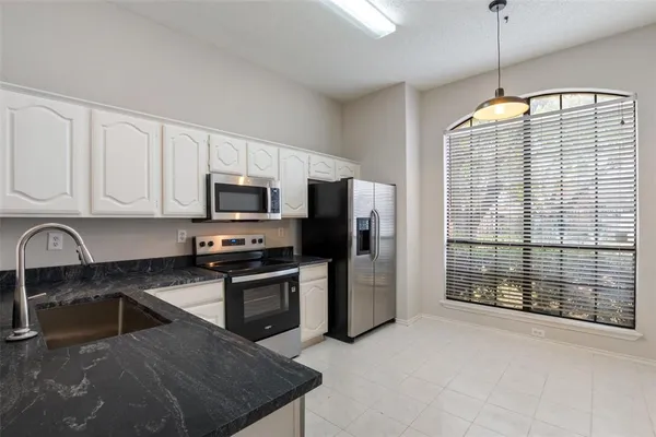 a kitchen with stainless steel appliances granite countertop a stove a sink and a refrigerator