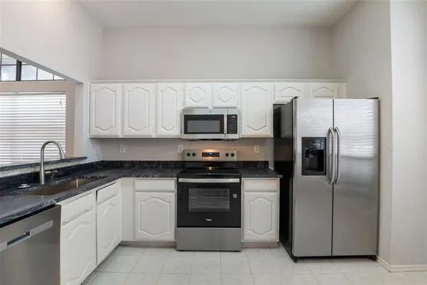a kitchen with white cabinets and stainless steel appliances