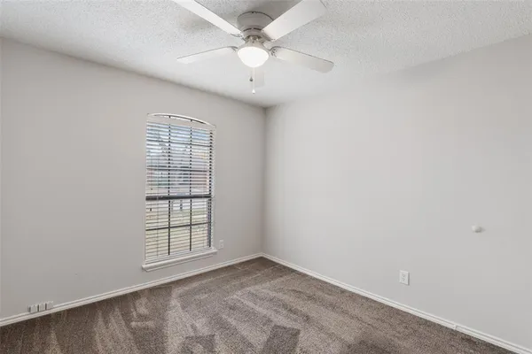 an empty room with closet and a ceiling fan