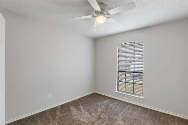 an empty room with closet and a chandelier fan