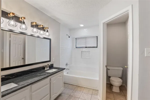 a bathroom with double vanity and a bathtub